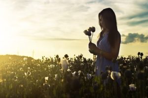 girl with flowers in meditation and solitude for energy healing